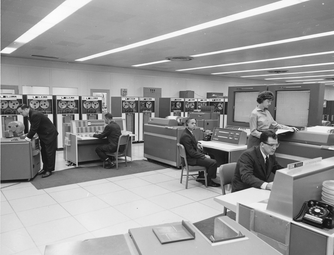 Operators at consoles and tape drives in an IBM 7090 computer room, early 1960s